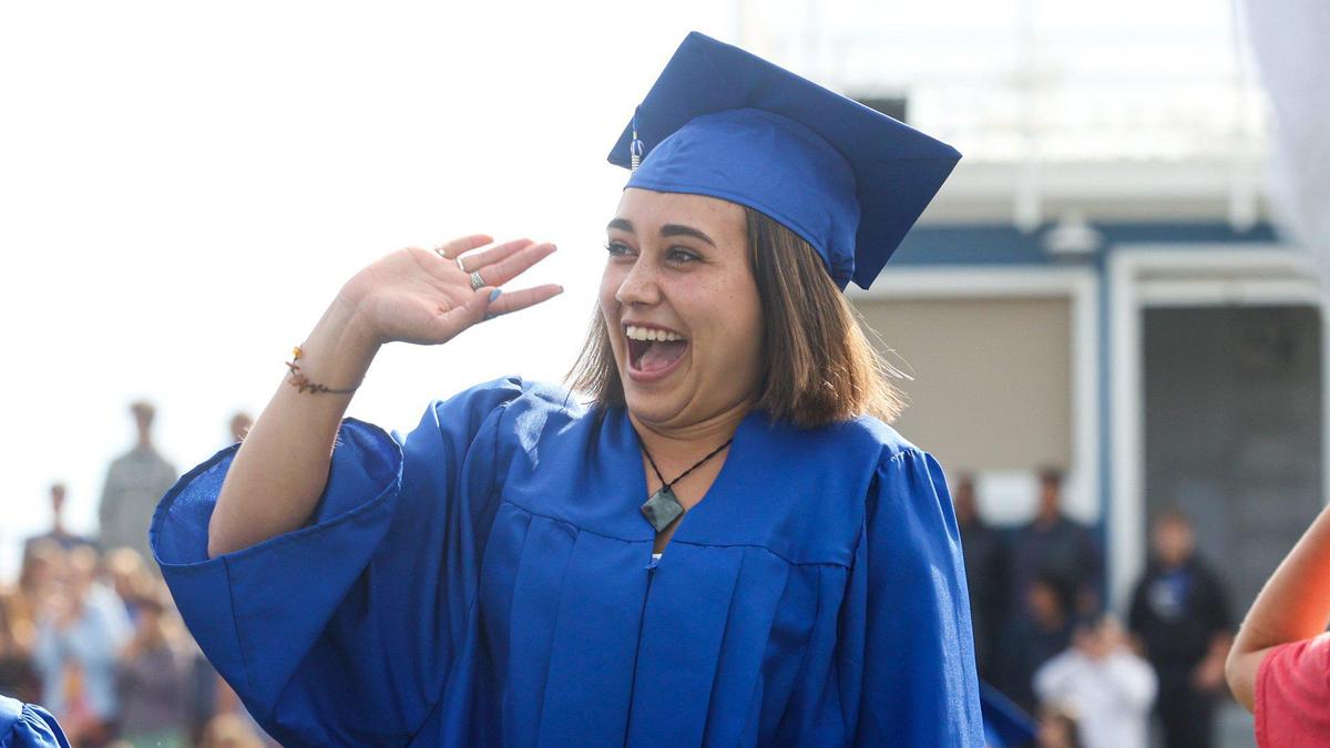 Faith De La Cruz waves to crowd. Morro Bay High School held graduation ceremony at the football stadium June 9, 2022.