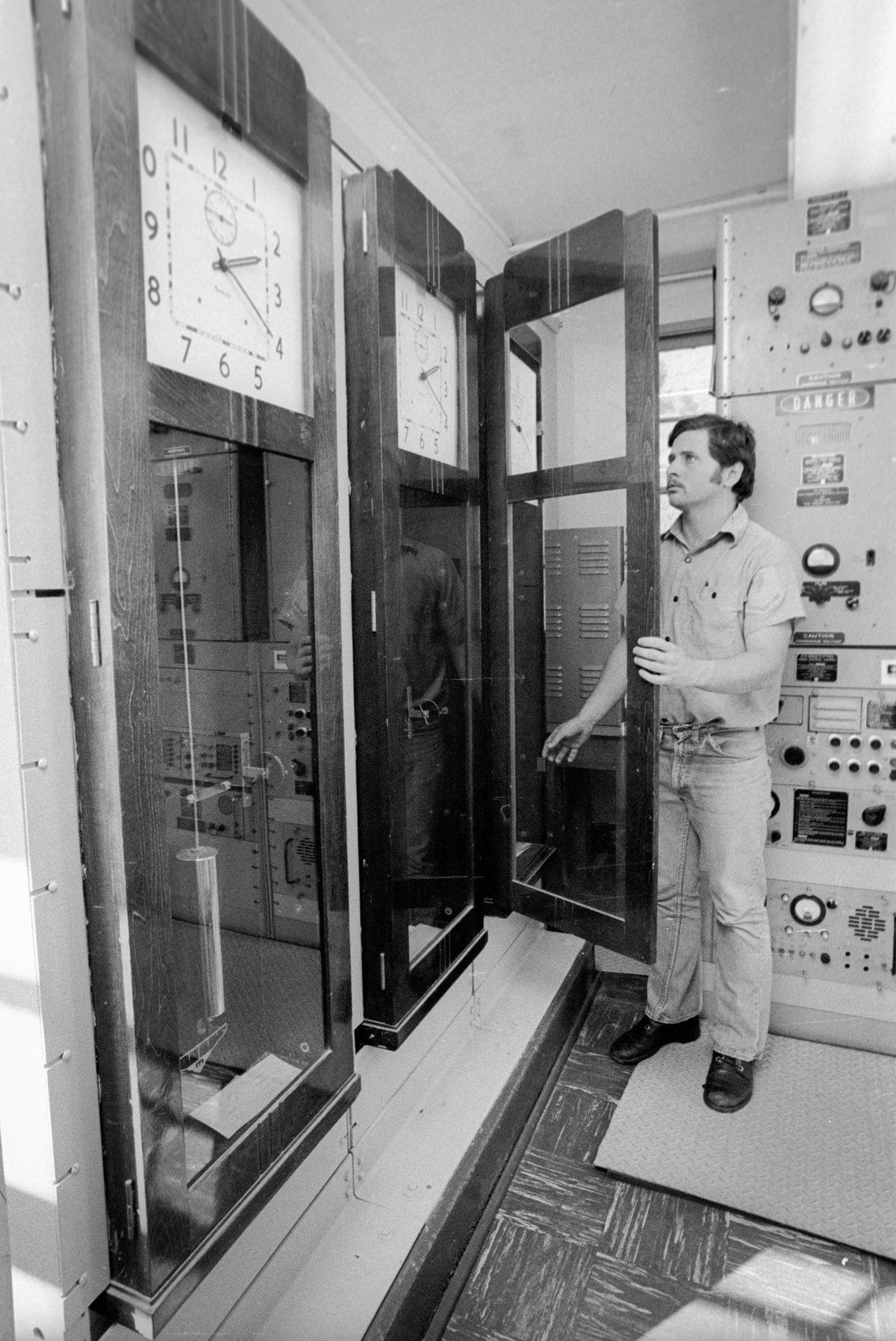 Coastguardman Gregory Scott adjust one of the simplex clocks — set to Grenwidh mean time. The Coast Guard was winding down manned operations at the Point San Luis Light House when the Telegram-Tribune reporter and photographer visited Oct 18, 1973. Automated operation was slated for summer of next year.