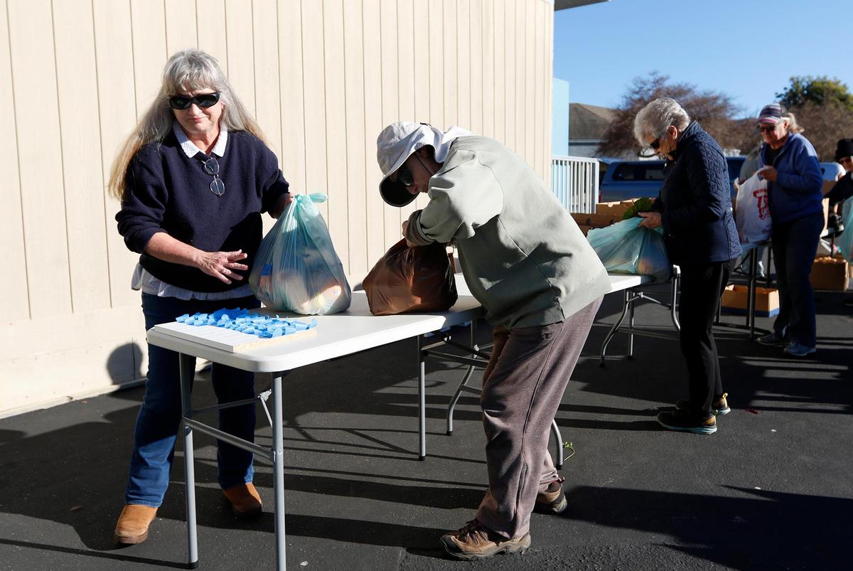Volunteer Carolyn Goossens oversees the counting of the bagged food.
