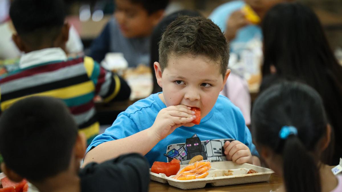 Trevor Woodworth, 7, enjoys watermelon slices on a warm day. Fresh and local is on the menu for healthier school lunches as students at Lillian Larsen Elementary in San Miguel eat on Aug. 22, 2022.
