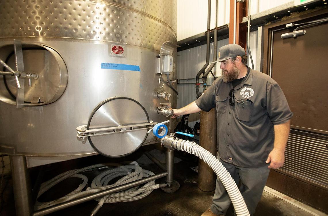 McPrice “Mac” Myers, winemaker at McPrice Myers winery in Paso Robles, checks the equipment while processing grapes on Thursday, Sept. 1, 2022.