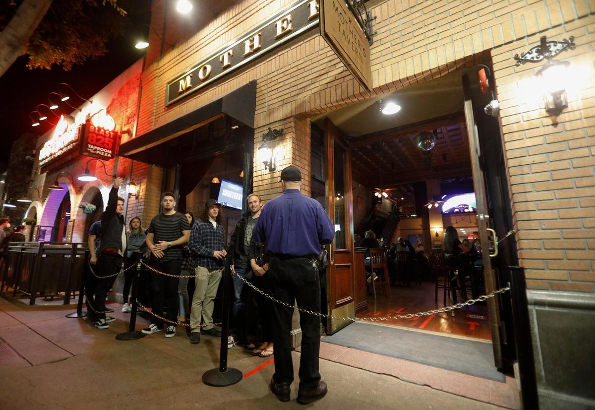 Patrons wait outside Mother’s Tavern after bars are allowed to reopen in San Luis Obispo County.