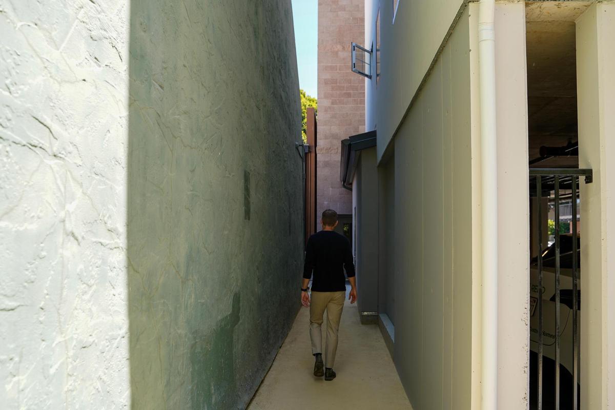 Abbott | Reed principal Aaryn Abbott walks in the alley between the newly-finished Artisan Apartments and Buen Dia Coffee in San Luis Obispo, pictured Thursday, June 12, 2025. The new 36-unit apartment complex utilizes an all-electric design and dense, tall infill techniques to place the units on a small lot along San Luis Obispo Creek.