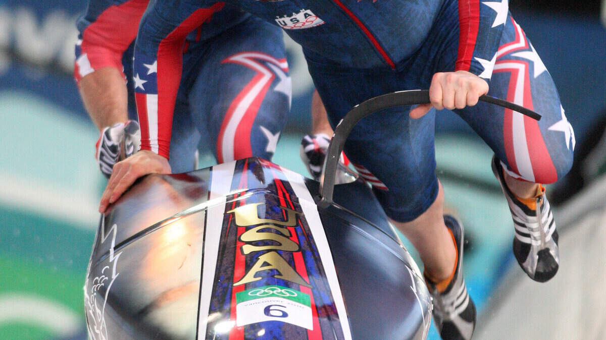 USA's Steven Holcomb, followed by brakeman Curtis Tomasevicz, jump aboard after pushing out of the starthouse in the men's two-man bobsled. (Steve Ringman / Seattle Times / MCT)