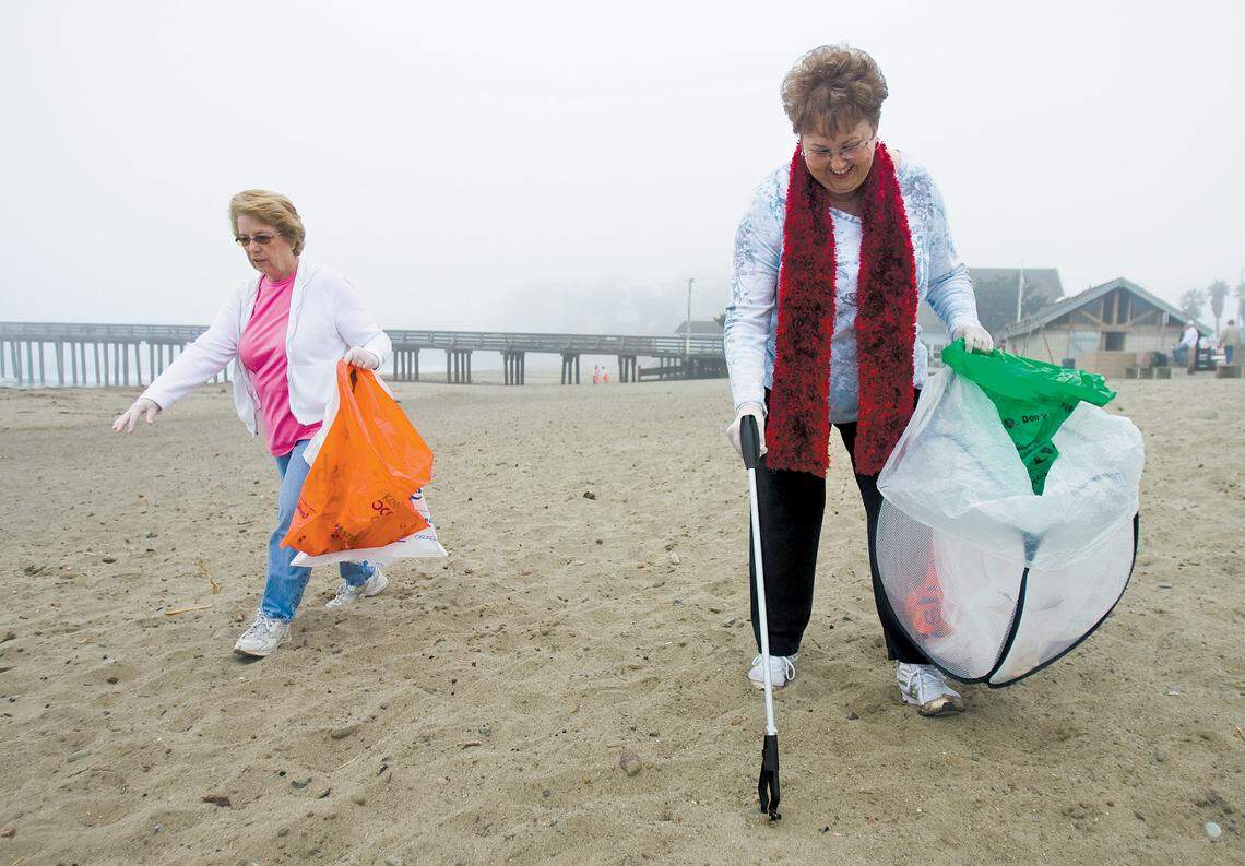 Ida Mackin, right, and Lanie Stier pick up trash in Cayucos during beach cleanup day in August 2009. 