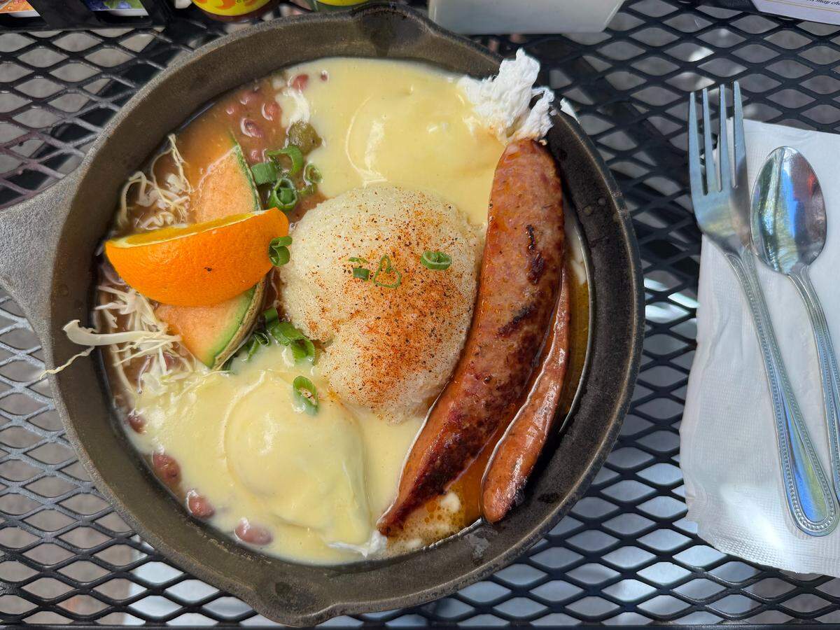 The Faitdodo at Bon Temps Creole Cafe contains Creole red beans with two poached eggs in hollandaise sauce, grits, grilled andouille sausage and a buttermilk biscuit.