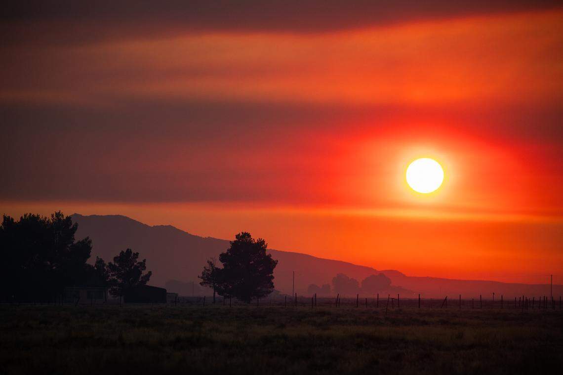 Smoke from the Gifford Fire turns the sky orange at sunset in a view from California Valley on Thursday, Aug. 7, 2025.