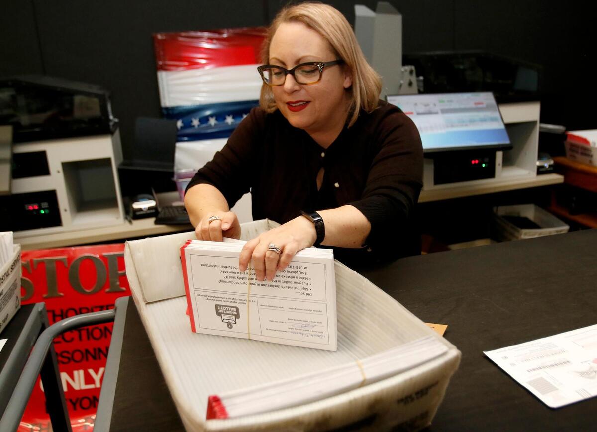 Deputy Director Clerk-Recorder Melanie Foster processes vote-by-mail ballots for signature certification on the day after the election, Nov. 9, 2022.