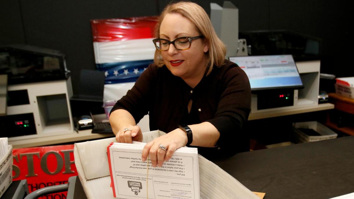 Deputy Director Clerk-Recorder Melanie Foster processes vote-by-mail ballots for signature certification on the day after the election, Nov. 9, 2022. The Elections Office will start counting ballots again on Friday and release another ballot count report that day at about 5 p.m.