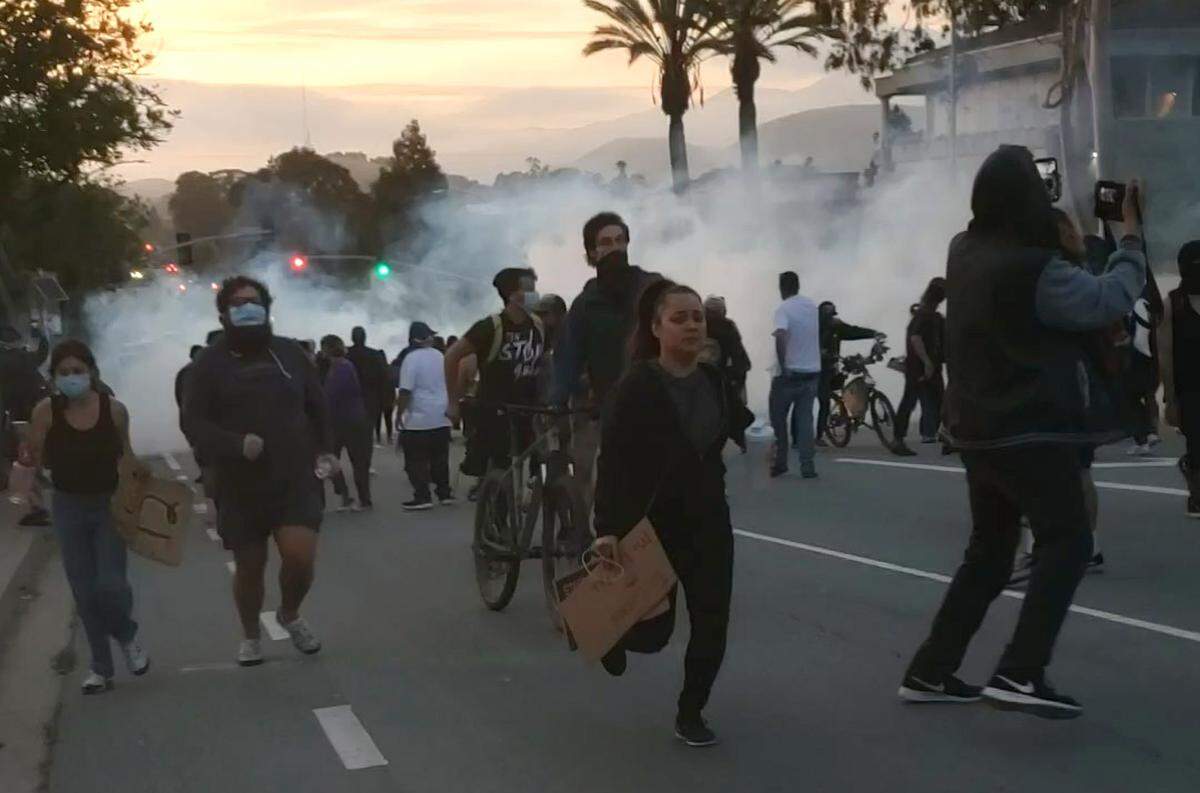 Protesters run south on Santa Rosa Street in San Luis Obispo after police deployed multiple rounds of tear gas and firecrackers to disperse the crowd.
