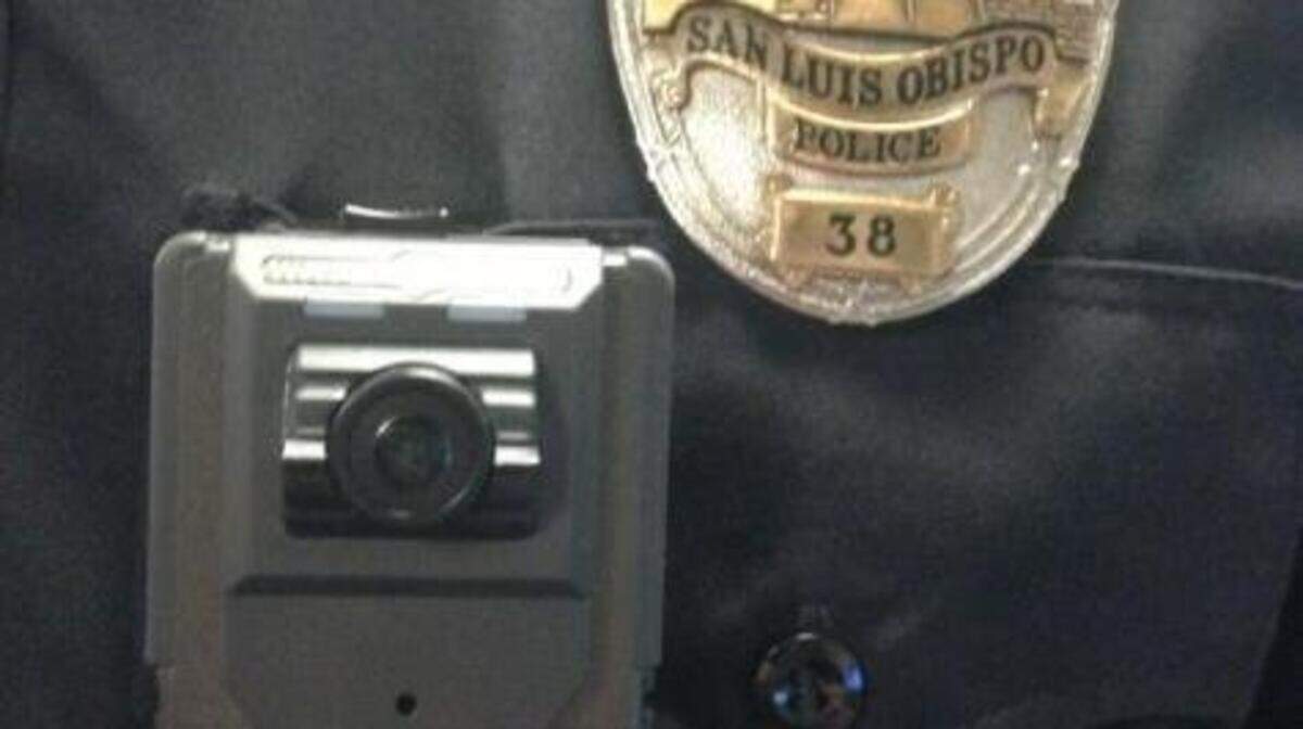 A body camera is shown being worn by a police officer.