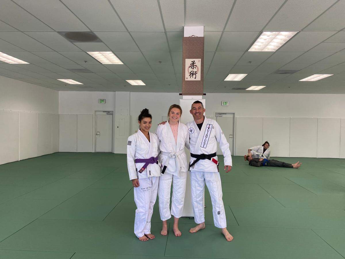 Retired Sergeants Melanie Franco and Eric Franco pose for a picture with San Luis Obispo Tribune Reporter, Lucy Peterson, at the new Virtus Brazilian Jiu Jistsu academy. Melanie Franco taught reporter Lucy Peterson basic self-defense moves.