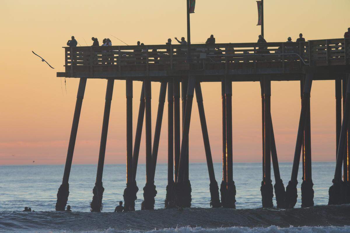 People enjoy fishing, surfing and selfies at sunset in Pismo Beach on Monday, Nov. 16, 2020. The Central Coast is experiencing king tides, the highest and lowest tides of the year. High tide on Monday was at 9:45 a.m. at 6.79 feet, with the low tide at 5:05 p.m. at -1.4 feet. The difference was more than 8 feet. Similar events will happen in December and January.