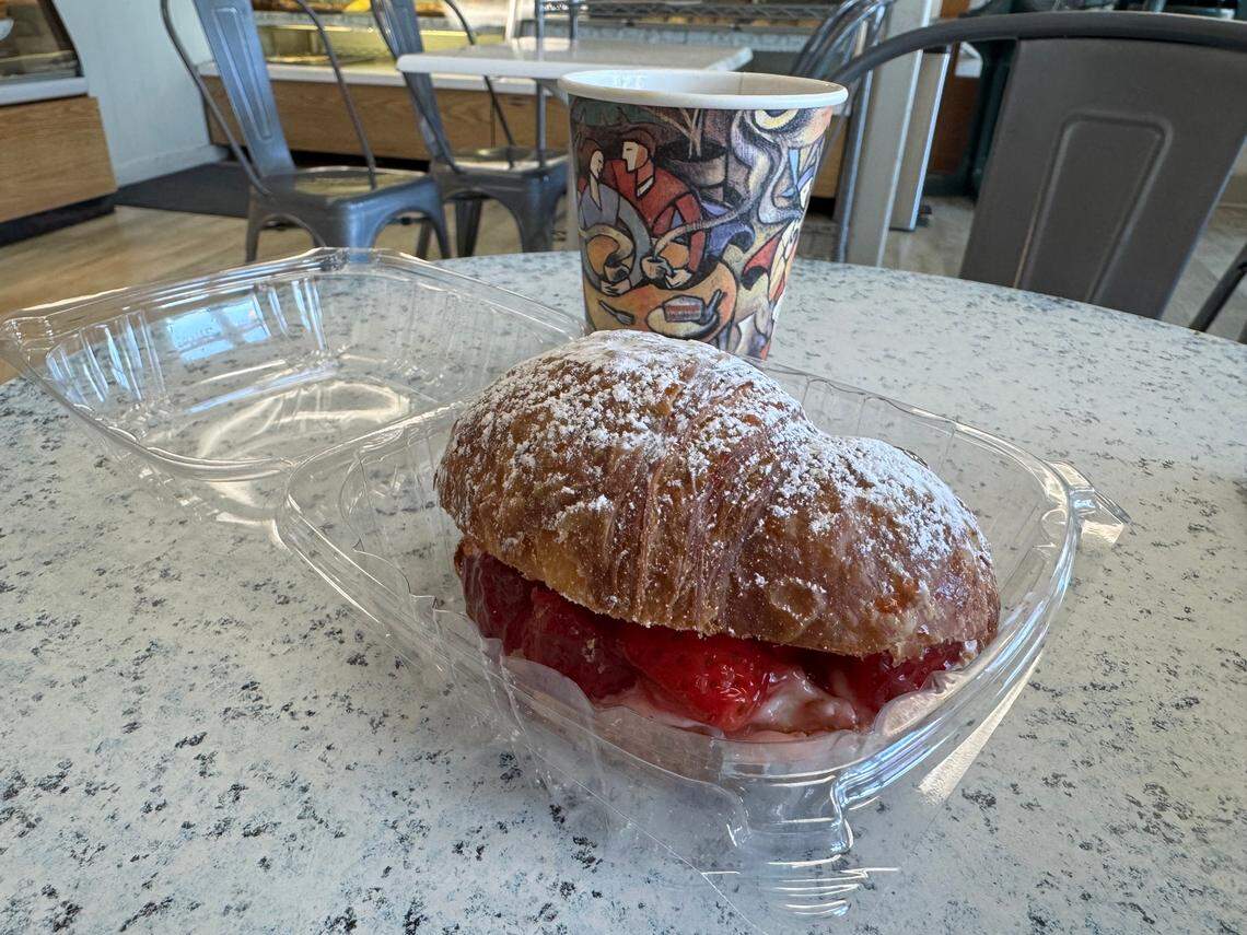 A photo of a croissant filled with strawberries and cream cheese and a drip coffee from La Parisienne in Morro Bay.