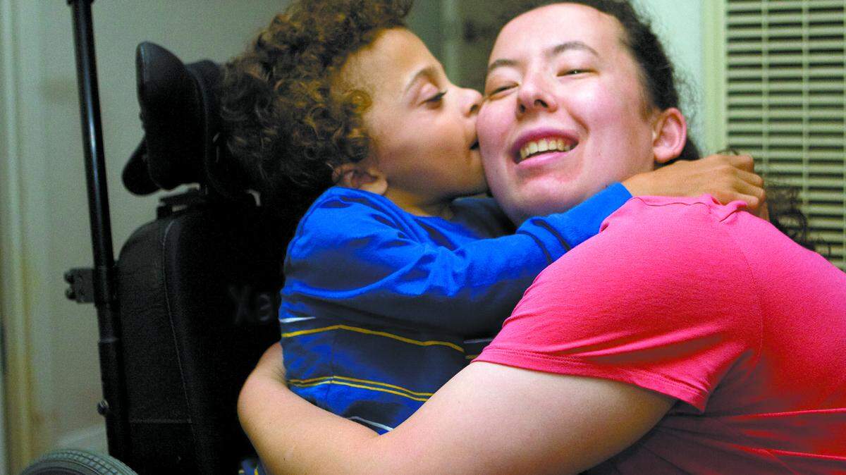 Susie de Groot hugs one of the children, Xander, who lives at a home operated by Sjany de Groot, Susie's mother.
