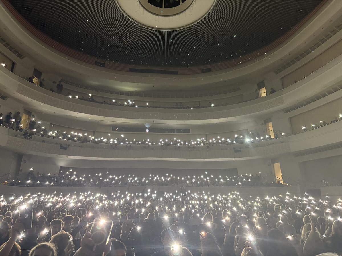 Members of the crowd lift their phone flashlights during a moment of silence to honor the life of conservative activist Charlie Kirk, who was killed on a college campus in September. A vigil was held at Cal Poly on Sept. 29, 2025.