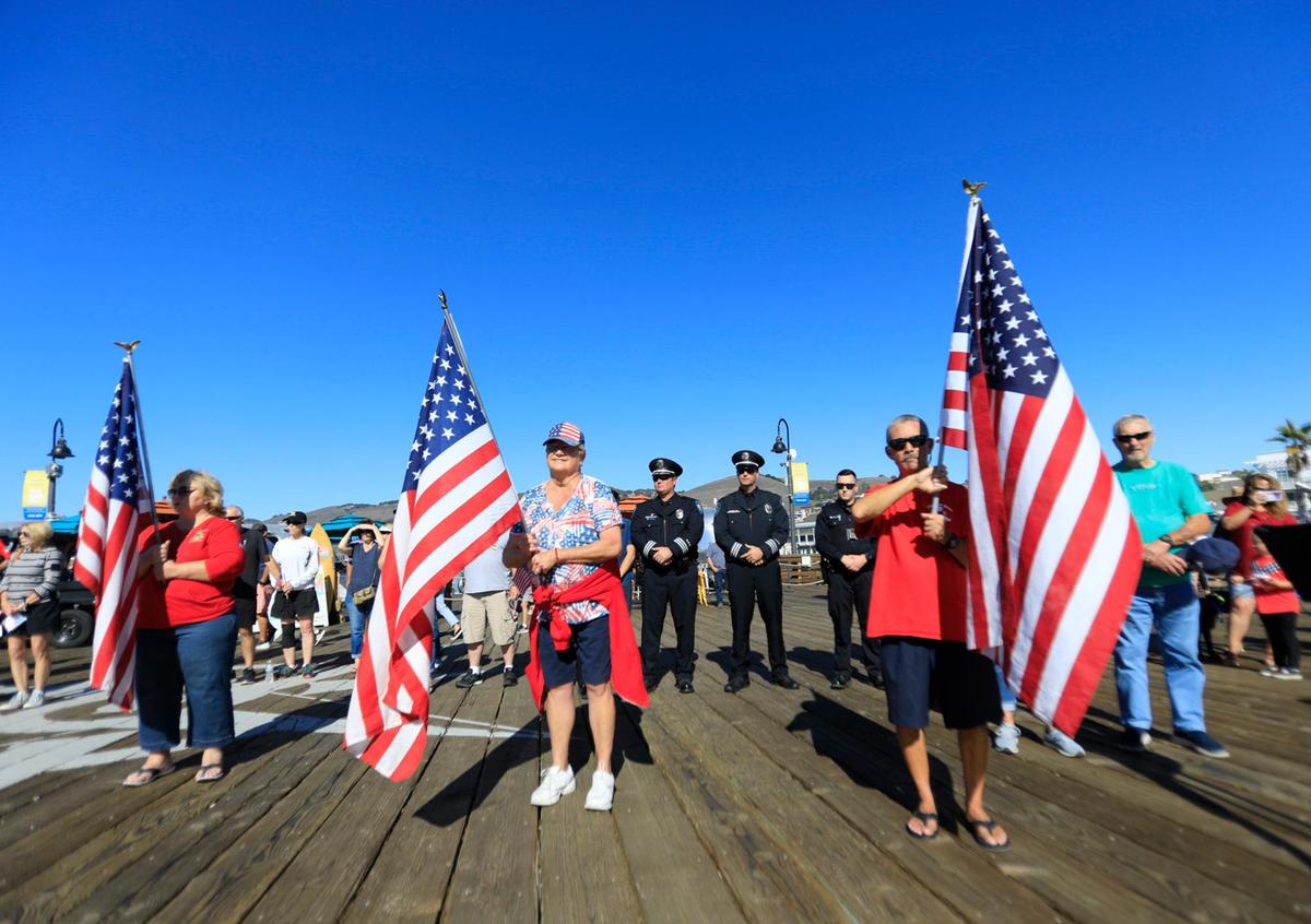 Representatives from the Pismo Beach Police Department stand behind the flag carriers during the Veterans Day event on the Pier on Thursday, Nov. 11, 2021.
