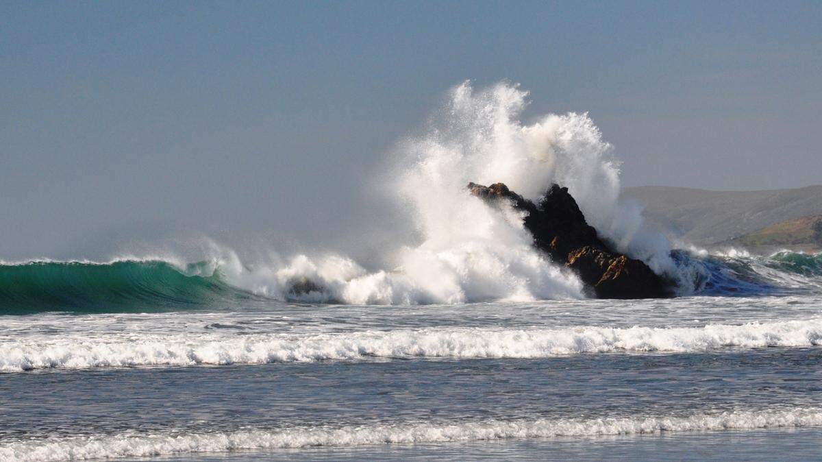 A long-period swell crashes over the ocean.