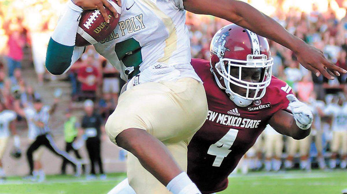 Cal Poly quarterback Chris Brown dodges New Mexico State's Winston Rose during the Mustangs' 28-10 loss on Aug. 28 in Las Cruces, N.M.