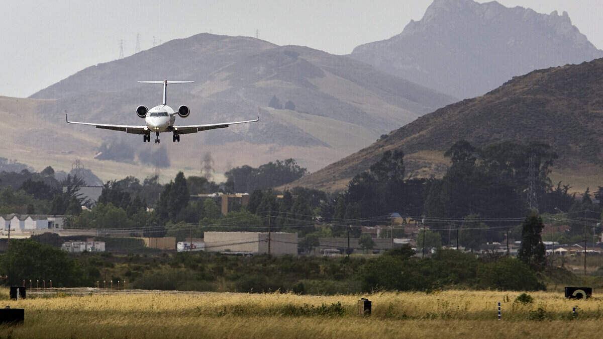 With Bishop Peak in the distance, a US Airways flight from Phoenix prepares for landing at the San Luis Obispo County Regional Airport.