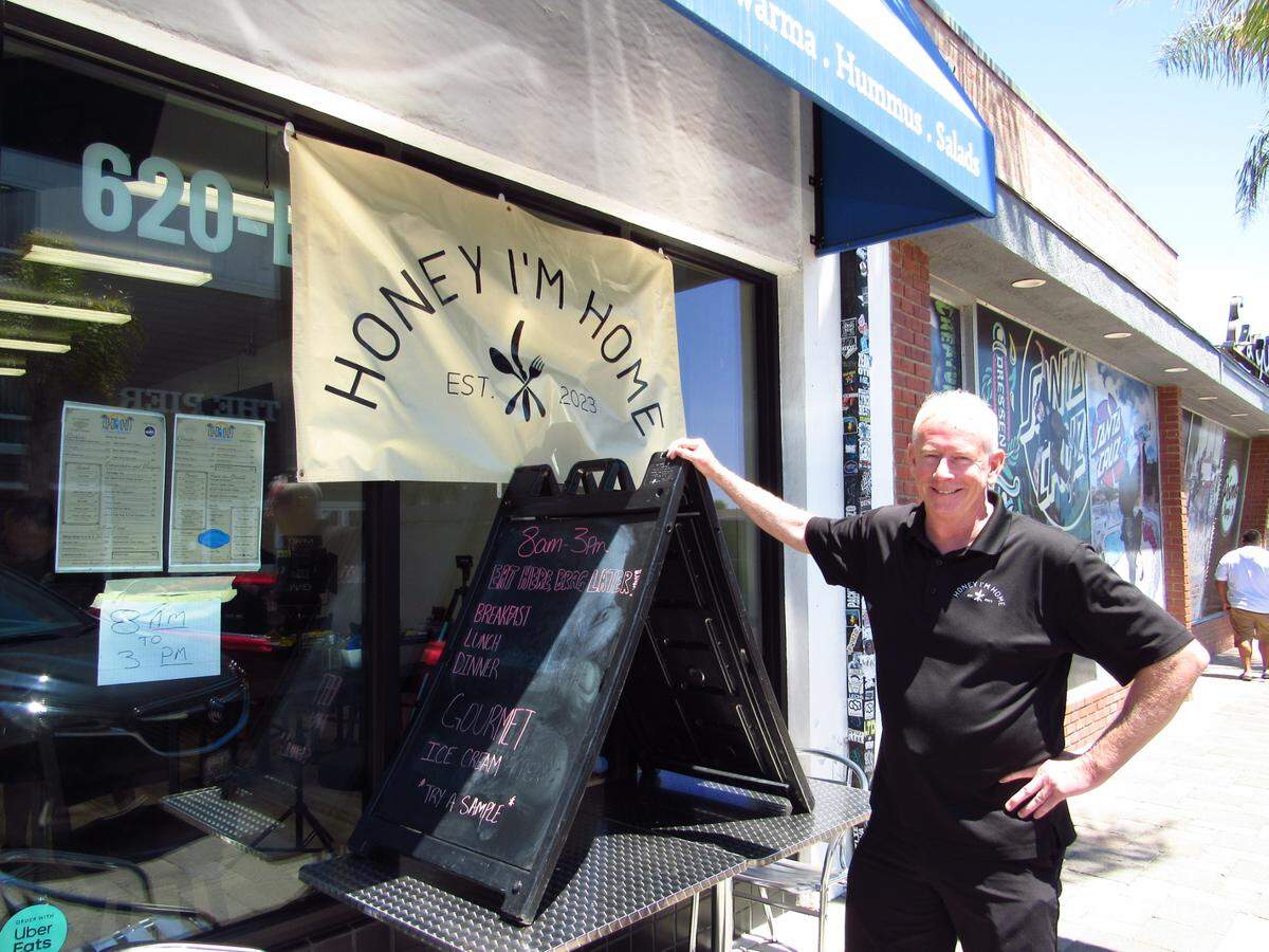 Edward Smith, co-owner of Honey I’m Home Pismo Cafe, poses in front of his new location in downtown Pismo Beach, seen here on Friday, July 18, 2025.