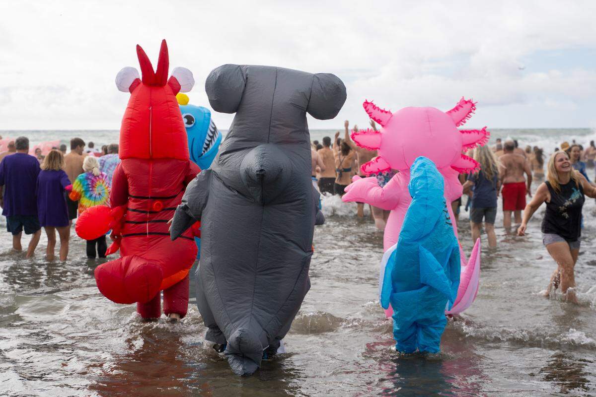 A family of inflatable sea creatures charge into the ocean during the annual Carlin Soulé Memorial Polar Bear Dip on Thursday, Jan. 1, 2026. The 46th annual dip drew thousands of divers even amid overcast and rainy weather.