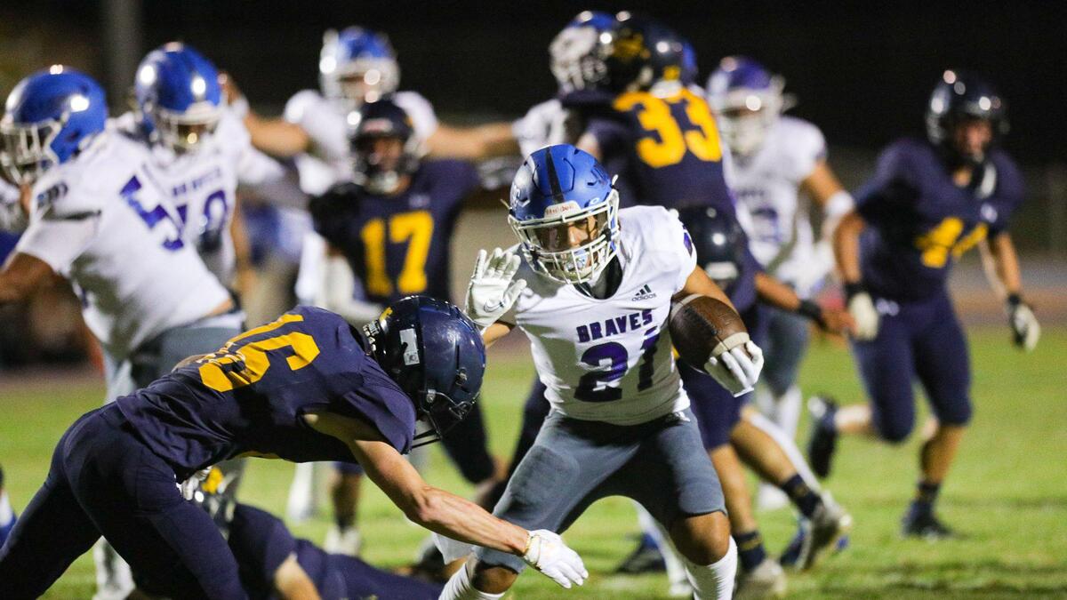 Marcus Bailon runs for Braves as Koa Kopcho pursues. Arroyo Grande fell to Lompoc 42-37 in a hard-fought Mountain League football opener on Sept. 16, 2022.
