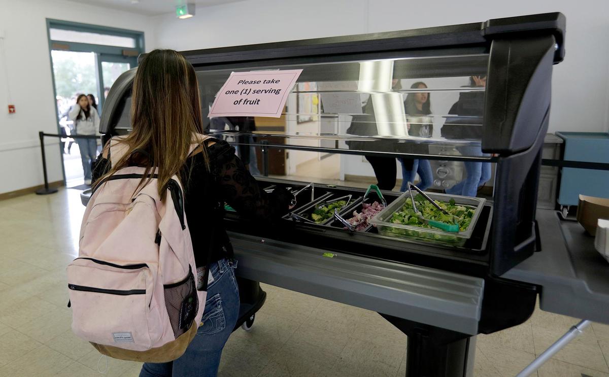 A student chooses a vegetable from the vegetable bar at Flamson Junior High School in Paso Robles. At the cafeteria, students are likely to find from-scratch meals made with fresh ingredients from local farms and ranches.