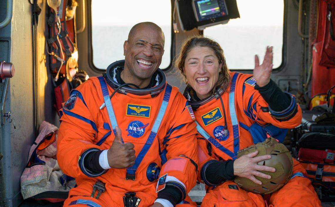 NASA astronauts Victor Glover, Artemis II pilot, left, and Christina Koch, Artemis II mission specialist, are seen sitting on a Navy MH-60 Seahawk from Helicopter Sea Combat Squadron (HSC) 23 on the flight deck of USS John P. Murtha after they were extracted from their Orion spacecraft after splashdown, Friday, April 10, 2026, in the Pacific Ocean off the coast of California.