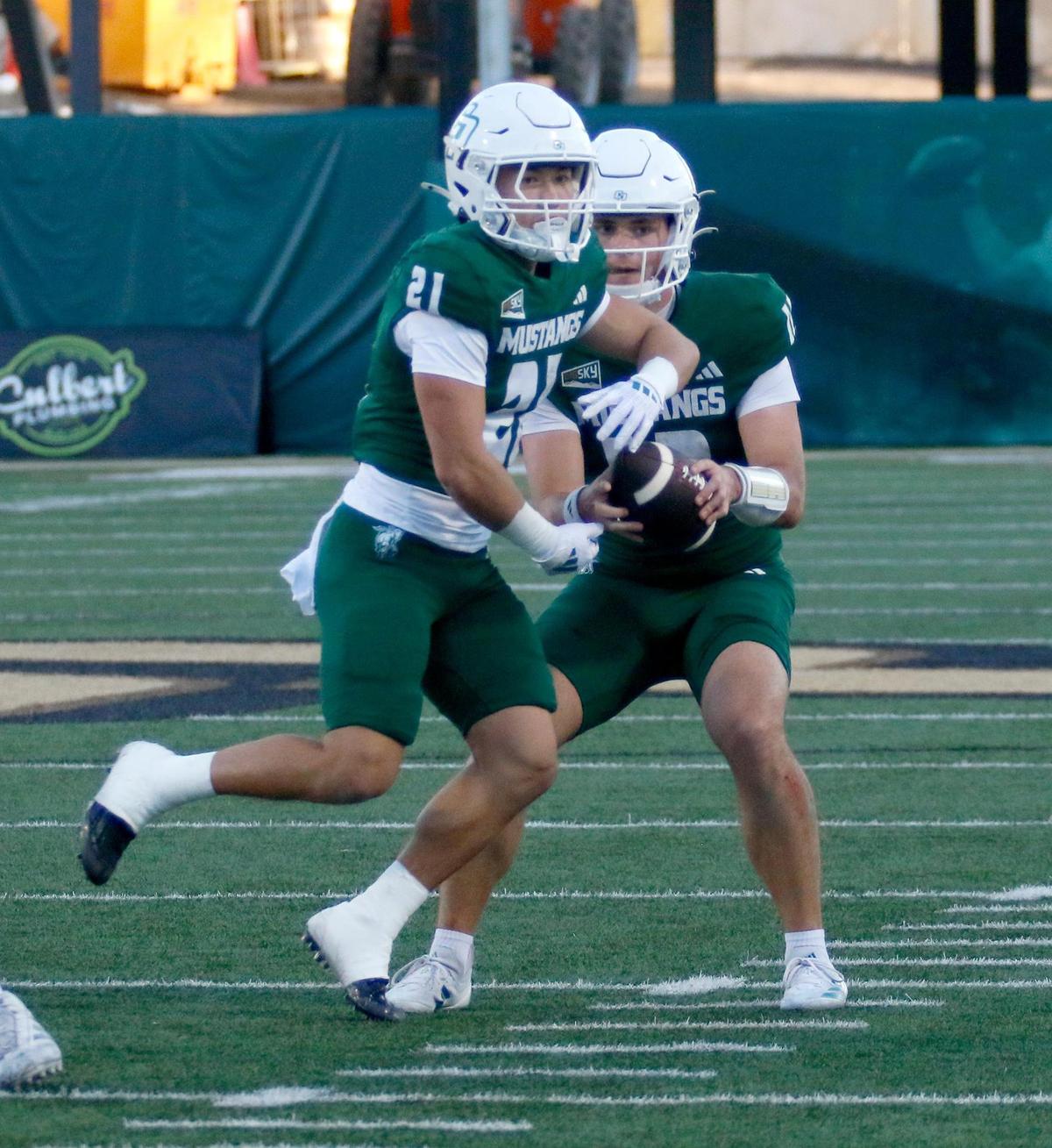 Cal Poly quarterback Jackson Atkins executes a play-action fake with running back Troy Fletcher. Cal Poly beat Sacramento State 26-23 in a college football game at Mustang Memorial Field on Nov. 16, 2024.