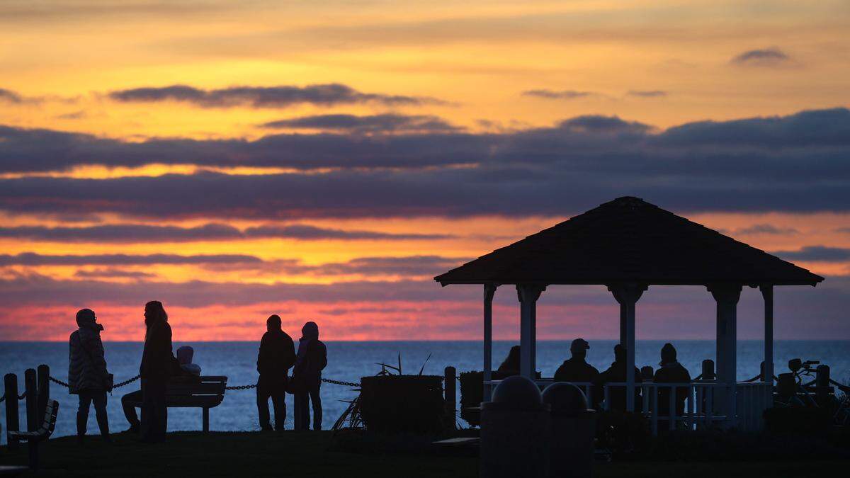 In Shell Beach, people gather to watch the sun set over the Pacific Ocean on Jan. 3, 2022, from the gazebo at Margo Dodd Park.