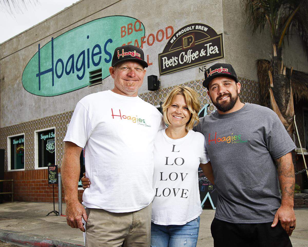 Jason Joseph, left, his wife, Kacey, and Nick Stieb are the owners of Hoagies, a Rasta-themed restaurant in Pismo Beach.