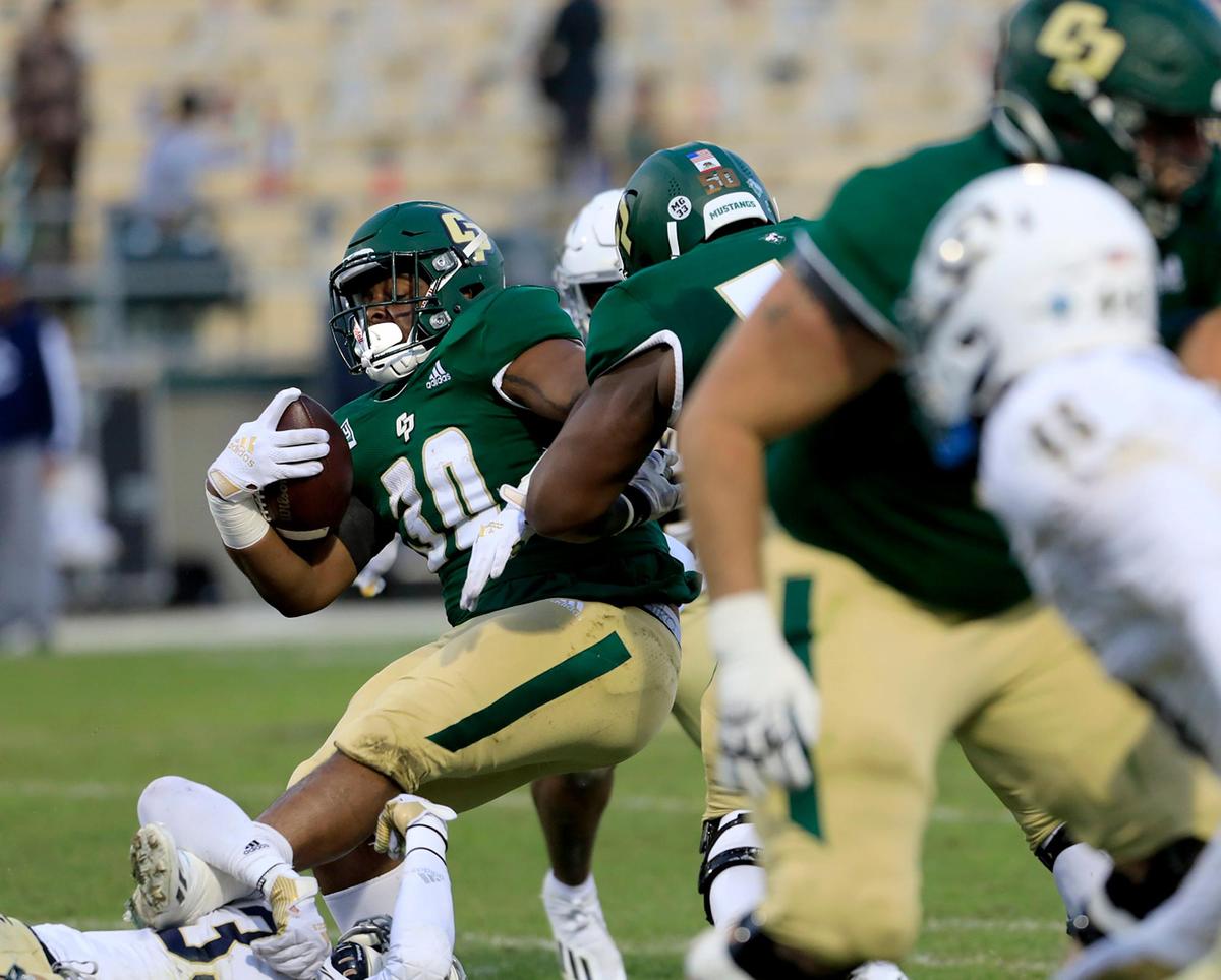 Cal Poly’s Sam Stewart Jr. (30) tries to resist being tackled during the Mustangs’ 24-13 loss to UC Davis at Alex G. Spanos Stadium on Saturday, Oct. 23, 2021.