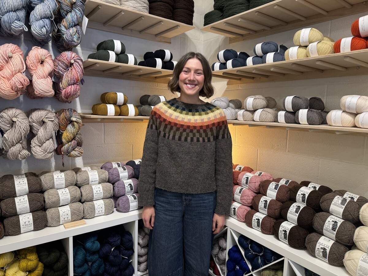 Rae Odom, owner of Morro Bay Yarn Shop, stands in front of international and U.S.-sourced skeins at her new shop.