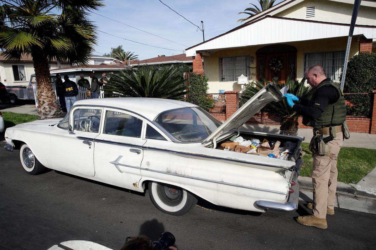 A member of the Los Angeles County Sheriff’s Department searches a vehicle during an investigation outside of a home in connection with a cold case Wednesday, Feb. 5, 2020, in Los Angeles. Search warrants were served at locations in California and Washington state in the investigation of the disappearance of Kristin Smart, the Cal Poly student who disappeared in 1996.