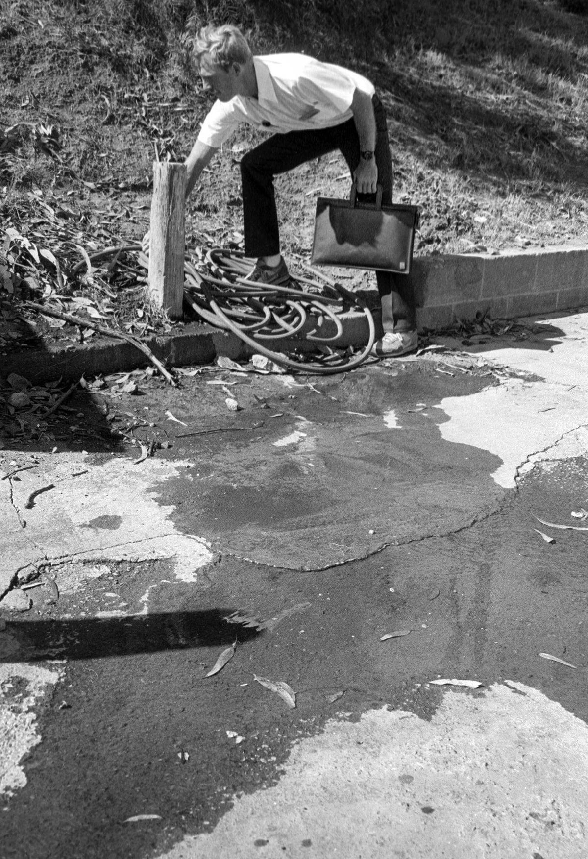 Ray Cardwell, hired to help the city of San Luis Obispo conserve water during a drought, shuts off a hose on Southwood Street on June 10, 1988.