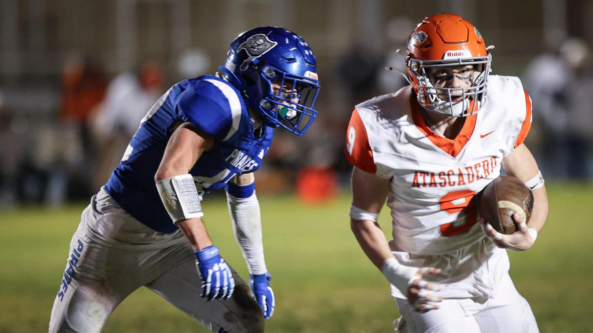 Bishop Resco runs for the Greyhounds, pursued by Colton Janovec. Morro Bay beat Atascadero 42-14 in a high school football playoff game on Nov. 15, 2024.