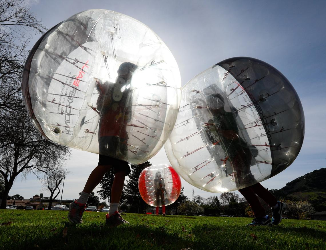 Knockerball SLO held a pop-up event at Santa Rosa park in San Luis Obispo on Saturday. Canyon Davis, 11, left, runs into brother Levi during the event under sunny skies.
