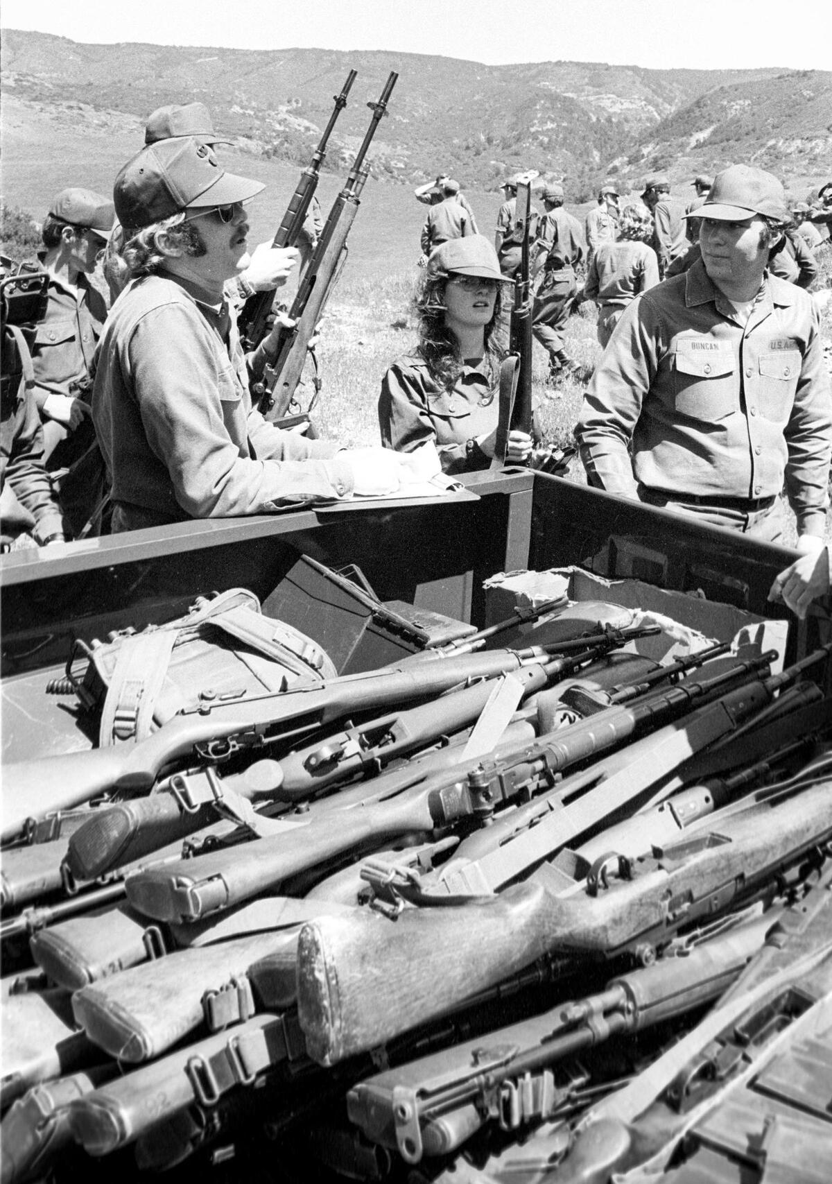 Cal Poly ROTC patrol leader passes out rifles to cadets involved in Saturday drill through San Luis Obispo’s rolling hillside. Cadets train on April 6, 1974.