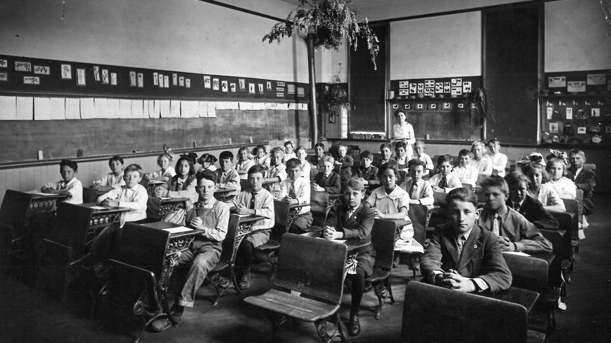 Mrs. Nicholson’s class at Emerson School in San Luis Obispo. About 35 students pose for a photo in an early 20th century classroom, in a room full of blackboards and folding desks.