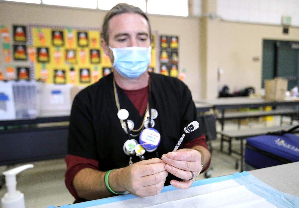 San Luis County Health Department Psych Tech John “Mike” Jamison readies COVID-19 vaccination syringes. The health department conducted a pop-up vaccination clinic at Santa Rosa Academic Academy in Atascadero, Friday, Nov. 3, 2022.