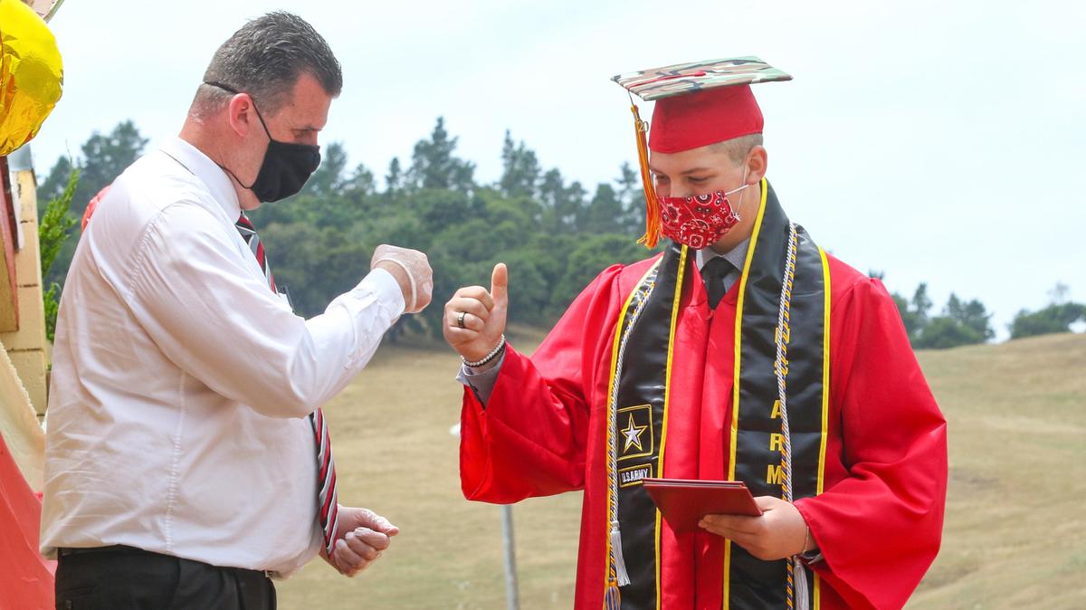 Daniel Cashdan has enlisted in the U.S. Army and gets a fist bump and diploma from principal Scott Ferguson. Coast Union High School graduation drive-in ceremony was held in front of the gym at the high school. The traditional indoor ceremony was changed due to coronavirus.