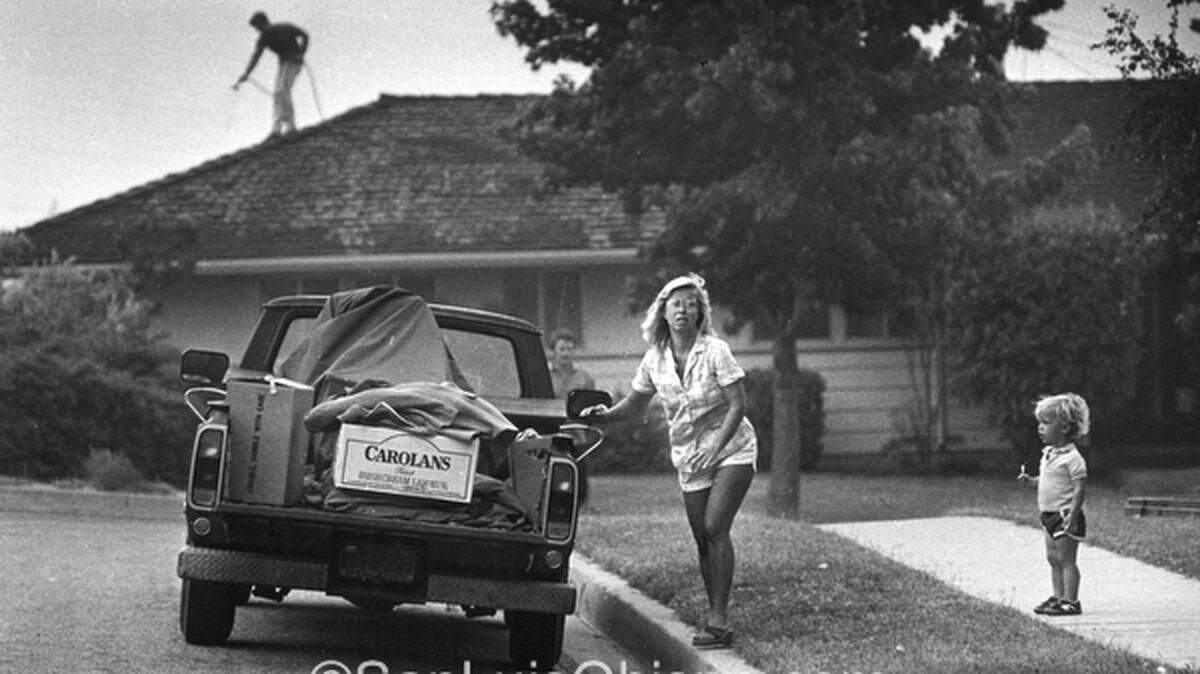 Becky Powell stops loading her car long enough to check the fire's progress on July 8, 1985, at her Johnson Avenue-area home in San Luis Obispo.