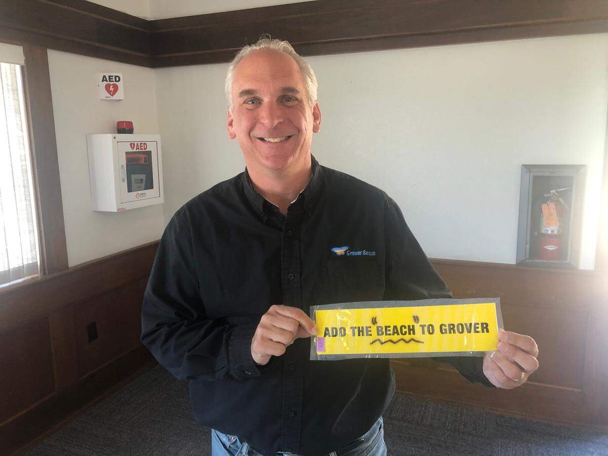 Grover Beach Mayor Jeff Lee holding his favorite item from the 1994 time capsule, a bumper sticker calling for what was then Grover City to become Grover Beach.