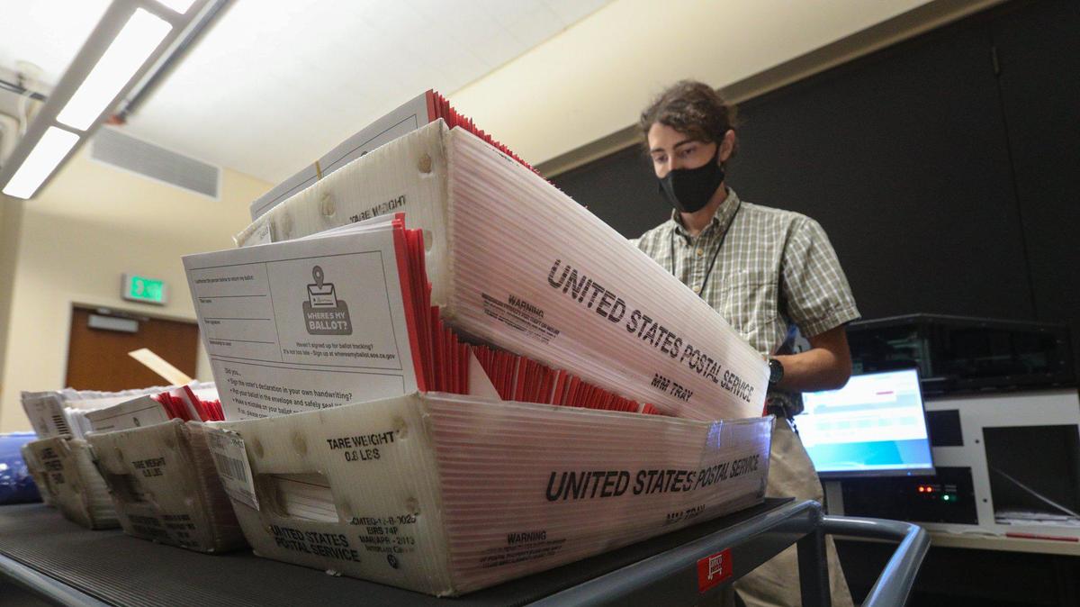 Eric Johnson, temporary election assistant, conducts one of the first steps in the ballot-handling process in 2020.
