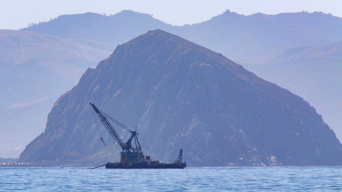 Morro Rock frames a barge stationed in the Estero Bay in 2019.