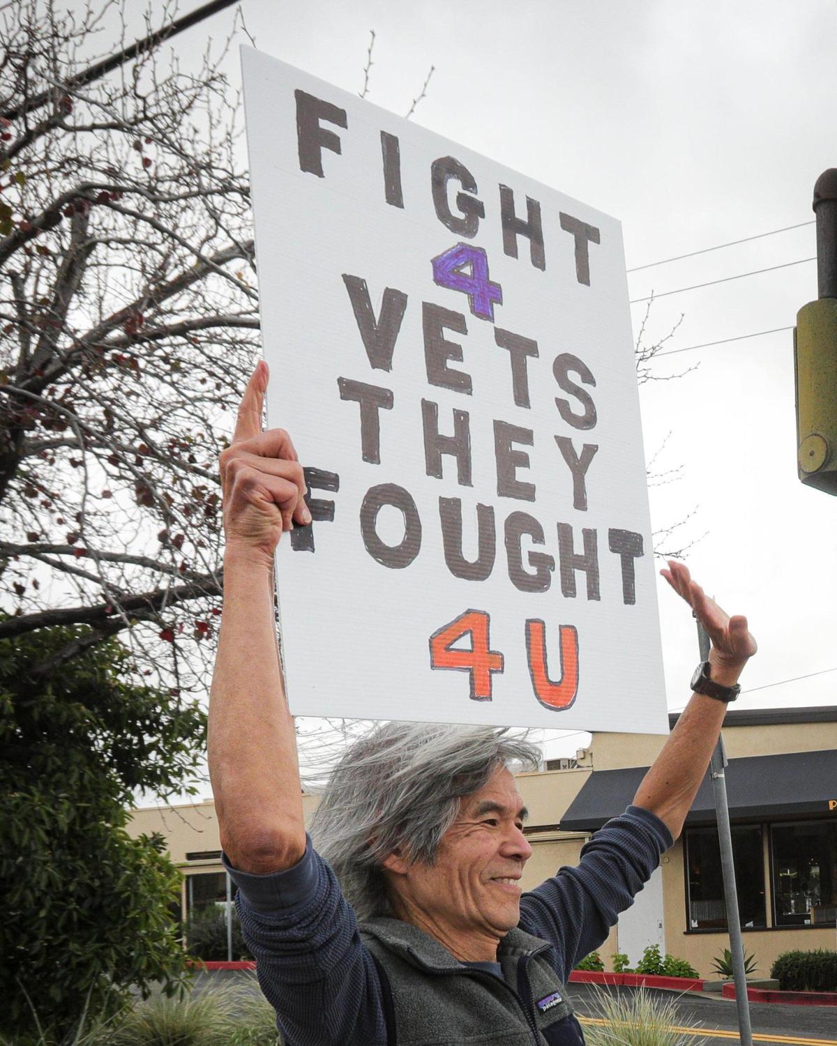 Kizen Sugano holds a sign in support of veterans. Over 50 protesters gathered near the Veterans Memorial Building in San Luis Obispo with signs in support of veterans services and critical of President Trump and Elon Musk on March 14, 2025.