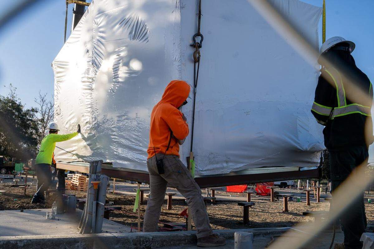 A construction crew carefully seats a prefabricated home on its ground screws at the Welcome Home Village on Thursday, Feb. 5, 2026. The Welcome Home Village will consist of 54 prefabricated, 3D-printed homes that will house homeless individuals.