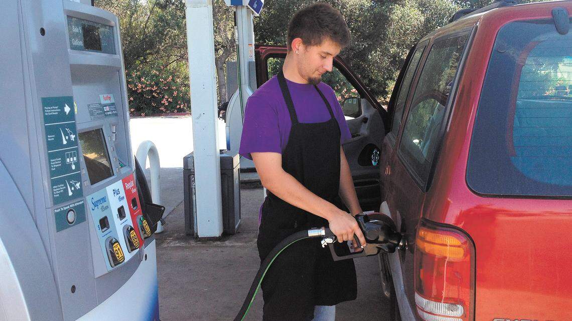 Thomas Sudderth, a Grover Beach resident and chef at the Rib Line in SLO, pumps gas at the Chevron station on Los Osos Valley Road near Highway 101.