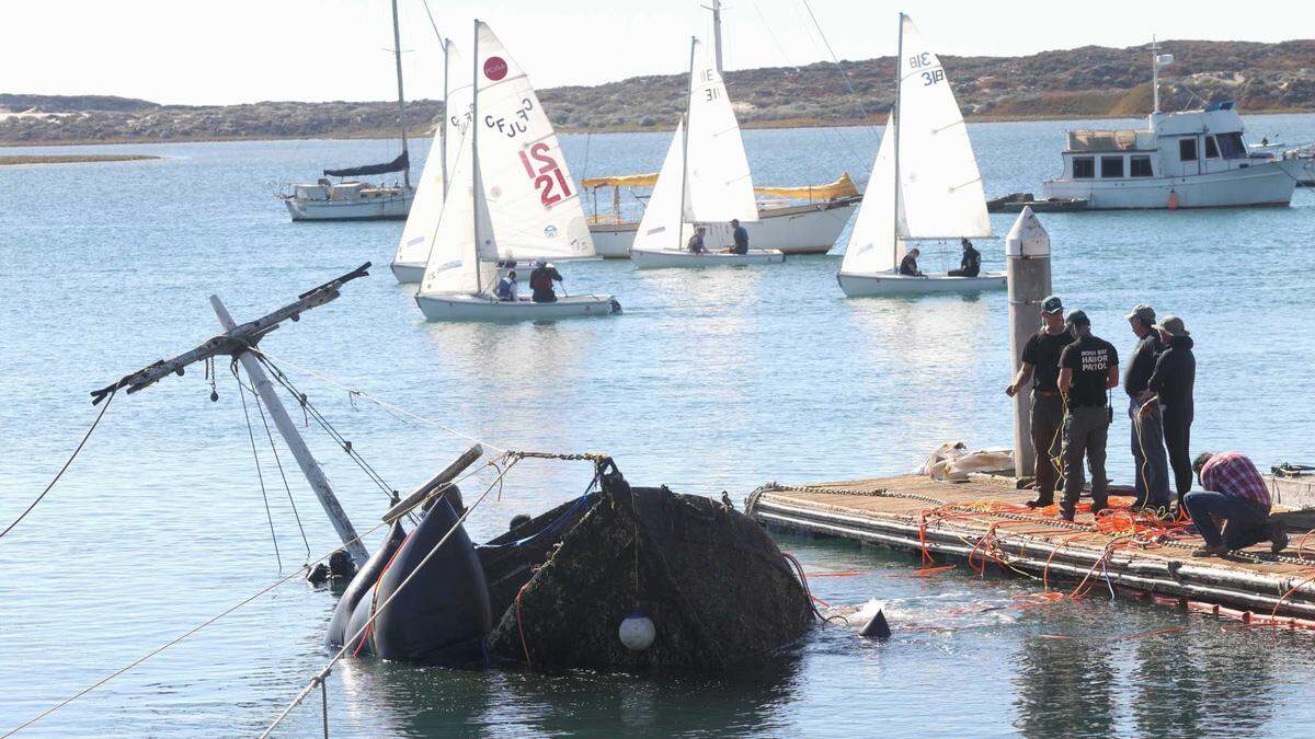 Workers use flotation devices to raise a sunken fishing boat from the Morro Bay seabed on Thursday, Nov. 11, 2021.